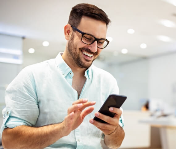 smiling-young-male-using-mobile-phone-app-playing-2024-03-11-15-04-24-utc (1)